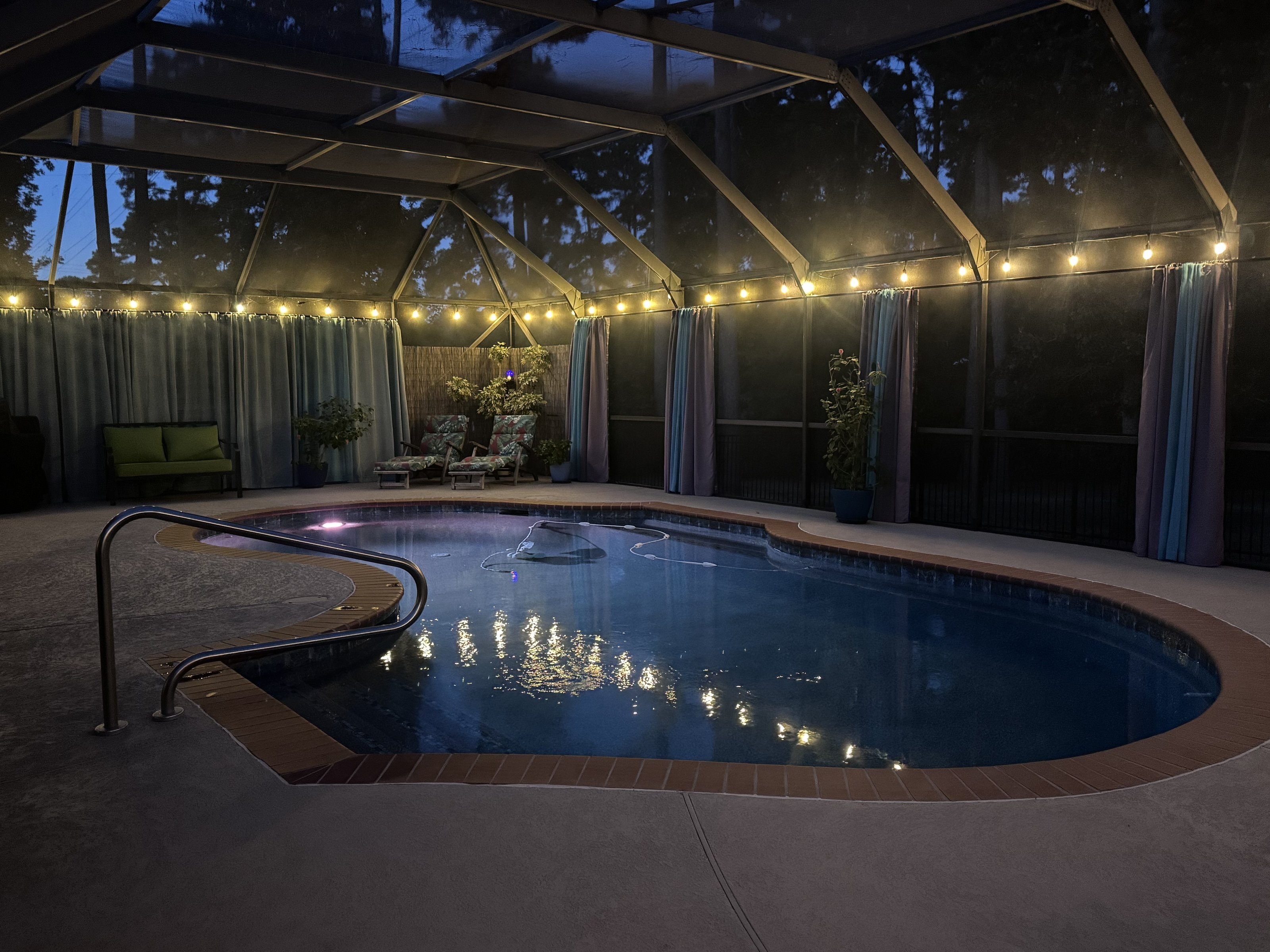 Pool at dusk under string lights